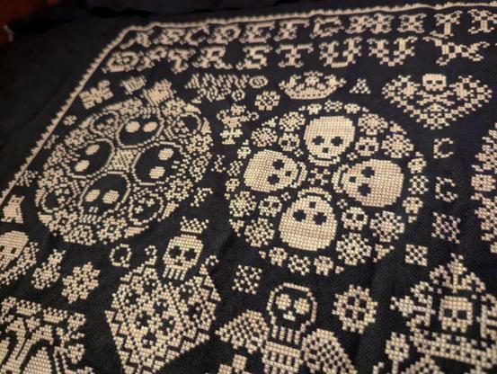 close up photo of some skull motifs in the pattern. i actually started this project in late 2019, not in response to the pandemic. but i kept working on it through 2020, because it seemed appropriate.