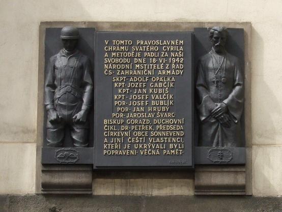 the memorial plaque: at left a paratrooper, at right a priest

in the middle in gold. the names of those killed at the scene or after a later trial and at the bottom a statement that this is also dedicated to the memory of all patriots executed for assisting the paratroopers