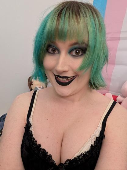 Revy wearing black lipstick and green blue black goth eyeshadow 
She's also wearing a black lace dress