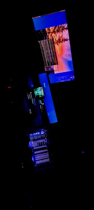 The photograph composed in absolute darkness, shows a setup of multiple IPS LED panels and a music mixing console in a dark environment. The top monitor displays a colorful image of a sunset with trees, while the adjacent monitor shows a terminal window with green and white text. Below, a smaller monitor displays a music player interface with the word "MUSIC" and a play button. The bottom part of the image features a music mixing console with blue backlighting, showing various controls and levels. The overall scene suggests a professional music production scene.

 Ovis2-8B

🌱 Energy used: 0.152 Wh