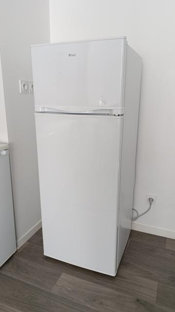 Photo d'un frigo blanc avec une petite partie congélateur en haut