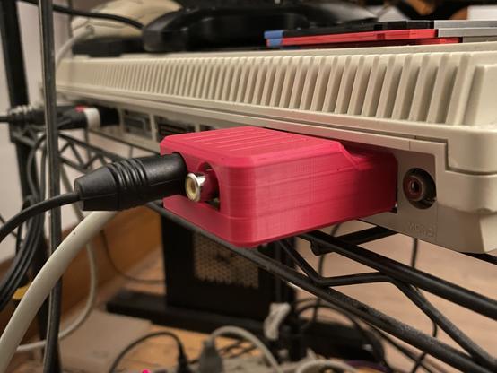 The device plugged into the back of an Amiga 500. A black cable is plugged into the S-Video port.