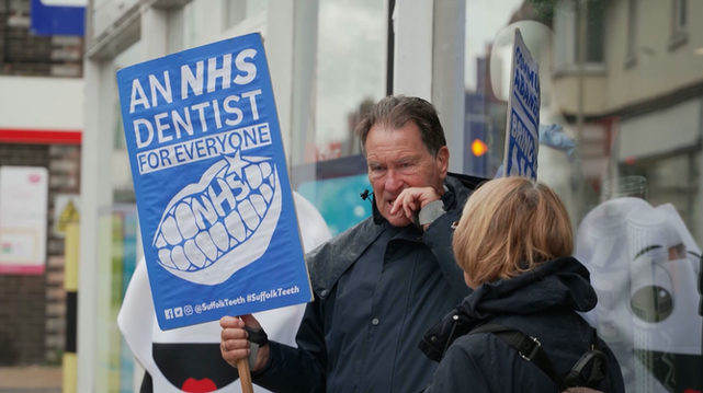 Uns manifestants reivindiquen la manca de cobertura de salut dental del sistema sanitari britànic (3Cat)