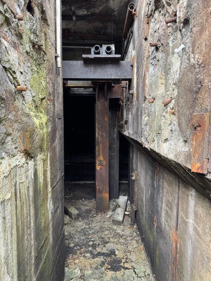 zwei rostende stahlträger am ende eines schmalen ganges aus bröckelnden betonmauern … aufgenommen im verfallenden alten güterbahnhof in dorrmund, der in kürze einem neubau für die wartung von ICEs der DB weichen muss