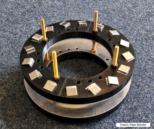 Fokussiertes Magnetsystem aus zwei gestapelten Ringen mit jeweils 16 FeNdB Magnetwürfeln mit einer Seitenlänge von 20 Millimetern. Der Innendurchmesser beträgt 160 Millimeter, das Magnetfeld von 20 mT hat über ein kugelförmiges Volumen mit einem Durchmesser von 50 Millimetern eine Homogenität von etwa fünf Promille. (Foto/©: Peter Blümler)