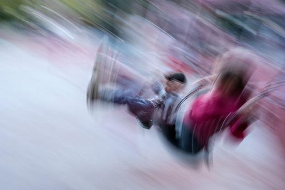 Blurry picture of two children on a swing.
