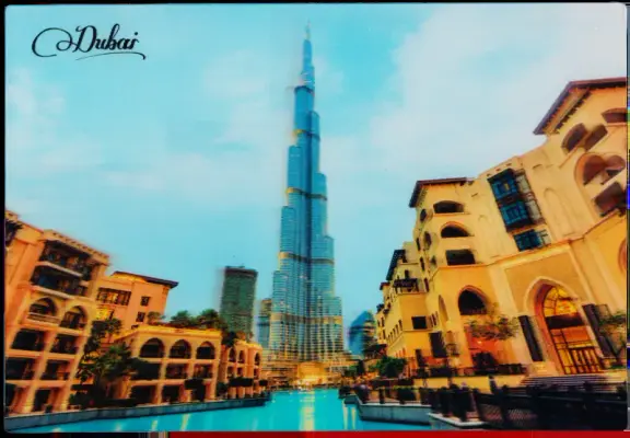 (A bad scan of a hologram of) the Burj Khalkifa, the enormous spire rising up the middle of the picture to a point, and the water & expensive homes framing its base on either side.