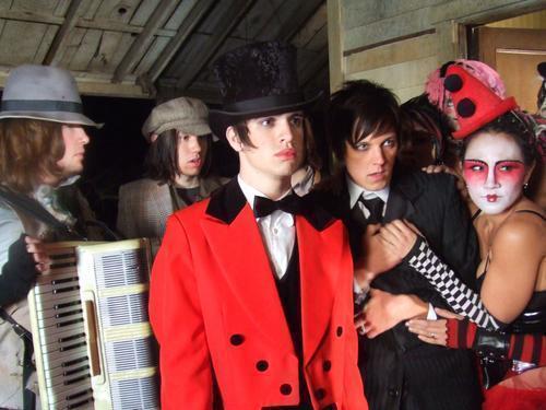 An emo band's ringleader hobnobs with turn-of-the-century spooky circus kids in his red suit jacket and top hat.