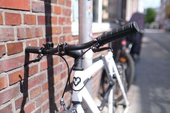 Foto von vorne auf den Lenker. Das Emblem von Bonvelo ist ein Herz mit zwei Kettengliedern