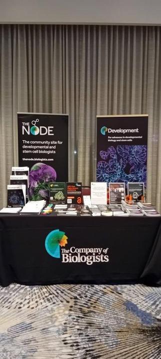 Event stand at SDB 2025, branded with The Company of Biologists logos and copies of journals.
