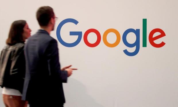 Trabajadores pasan junto al logo de Google (REUTERS)