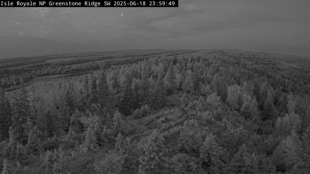 From one of the highest Isle Royale peaks at 1,133 feet above sea level (roughly 530 feet above Lake Superior), the Greenstone Ridge Southwest Webcam at the peak of Mount Ojibway gazes across the spine of the Greenstone Ridge from the Ojibway Tower. It captures a southwest vantage point, a swath from Moskey Basin on the left to Sargent Lake on the right. The webcam is solar powered and communicates multiple times per day, year-round, when power and communications infrastructure allows.