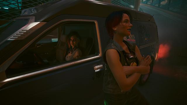 Cyberpunk 2077 screenshot Judy sitting in the driver’s seat of a van looking out the side window at player character leaning against side of van with arms crossed and a small smile.