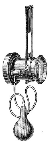 The image depicts a vintage mechanical device, likely from the late 19th or early 20th century. The device features a cylindrical body with two flanges on either side, suggesting it might be part of a larger apparatus. A prominent vertical rod extends from the top, with a series of parallel lines indicating a scale or measurement mechanism. Below the cylinder, a bulbous component is connected by two flexible tubes, resembling a syringe or pump. The overall design is intricate, with detailed engravings highlighting the mechanical nature of the device. The monochromatic illustration emphasizes the device's historical context and mechanical complexity.