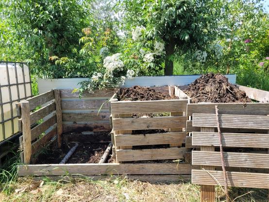 3 bay compost system with the left bay empty and 2 aeration pipes visible.  
The wooden fronts of the bays are removable and move with me as I work