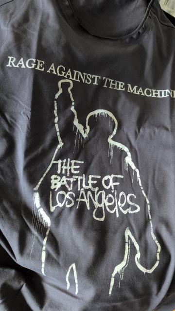 Rage against the machine
T Shirt Graffiti Style
The battle of Los Angeles
Umriss einer Gestalt mit hoch gereckter Faust