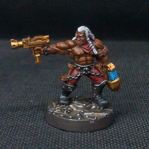 an extremely handsome, shirtless muscular man with a pair of golden guns. he has red pants and a chunky chain belt