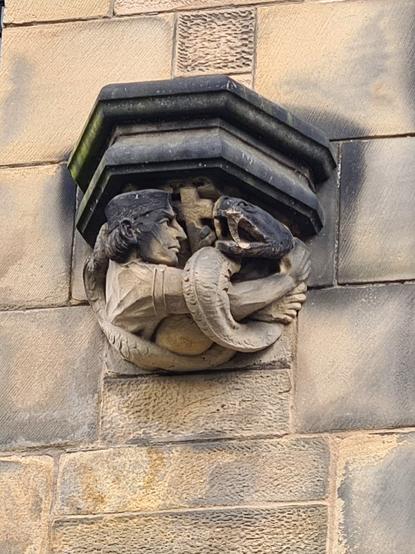 A sculpture of a man wrestling with a giant snake.