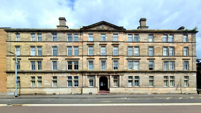 A large, four-storey Classical style late Victorian sandstone building.