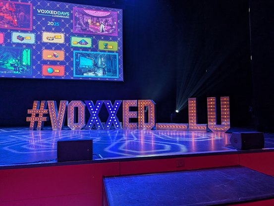 New York theater styled letters spelling "#VOXXED_LU"