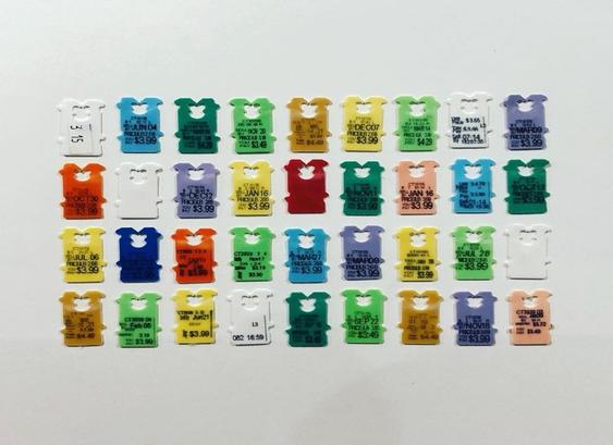 A colourful collection of bread tags arranged in a grid against a grey surface.