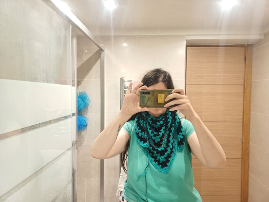 Selfie en el espejo del baño con Emochal envuelto al cuello, los tres picos caen por el pecho.