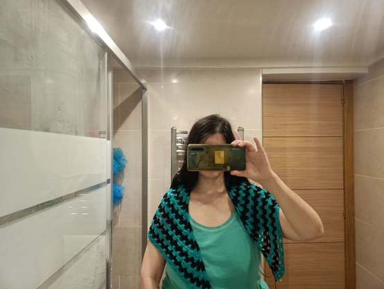 Selfie en el espejo del baño con Emochal echado por los hombros como un chal, cubre hasta la mitad del brazo y un poco del pecho
