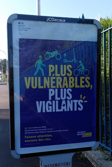 Affiche de la sécurité routière avec le message "Plus vulnérables, plus vigilants" avec des pictogrammes représentant un piéton, un 2RM, une trottinette, un cycliste.