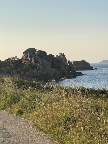 Rocks on the Pink granite coast between Perros Guirec and Ploumanac’h during the Golden Hour. In the background 2 of the Sept Îles
