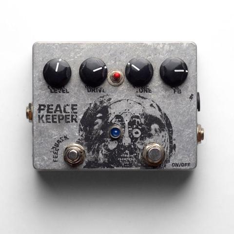 Photo of a Peace Keeper pedal from above. It's a bare aluminum enclosure with a black silk screen of.. an android coming out of their skin?
The important bit is there's a feedback footswitch :)