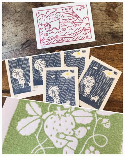 Three linocut prints i have made: a goat in a field, a character and their dog under the rain, and a tiny character holding a giant strawberry.