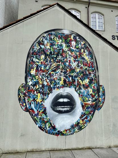 An artist depiction of a face, with only the lips showing. The rest of the face is covered in graffiti and the eyes and nose are not depicted.