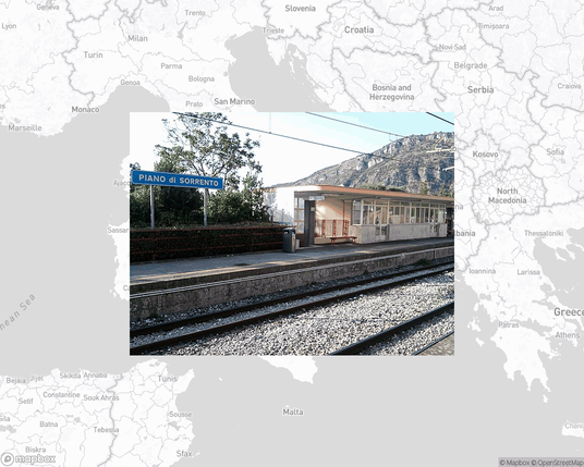 A photo of or from a train station from the linked website, overlaid on a cropped world map where it's located.