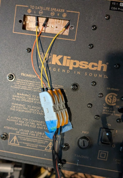 Small wires attached to a PCB board for a stereo speaker system. They are temporary wires used for attaching the speakers.