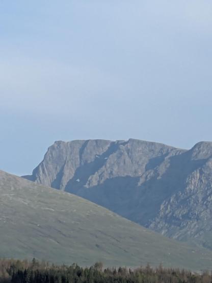 distant mountain partially in shadow. two white snow patches in a shadow look like demon's eyes