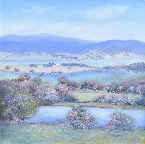 A landscape painting of an Australian country scene rendered with a palette knife in soft blues, pinks and greens. There is a partly cloudy sky, soft blue hills, distant gum trees and a few farm houses in the middle distance. In the foreground is a lake surrounded by gum trees.