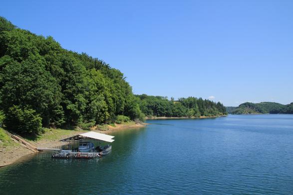 Westufer der Wahnbachtalsperre am Damm. Blauer Himmel und im Vordergrund eine Anlegestelle für Boote
