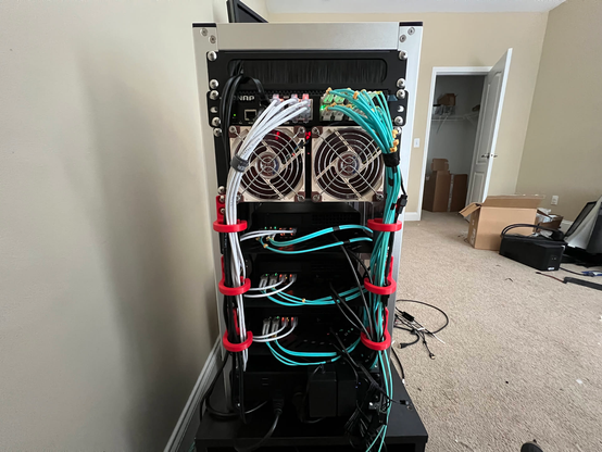 The rear of the minirack build in the T2.  From top to bottom: QNAP 16-port 10GbE switch with all the ports in use, two Noctua NF-9A fans, three Minisforum MS-A2 servers with dual 2.5GbE and dual 10GbE connections.