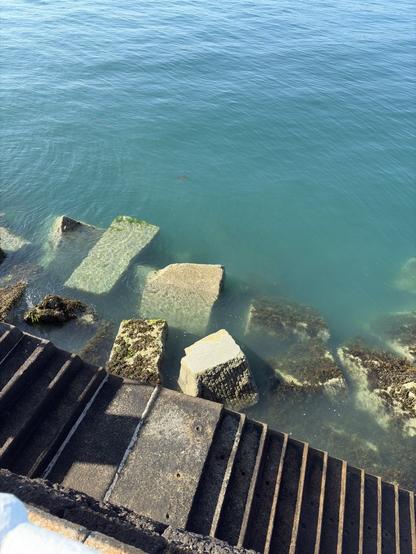 Image of some large rocks that are being used to protect a pier in Jersey, Channel Islands.

Behind the rocks is a stone staircase to allow access from the pier to the sea and vice versa.
