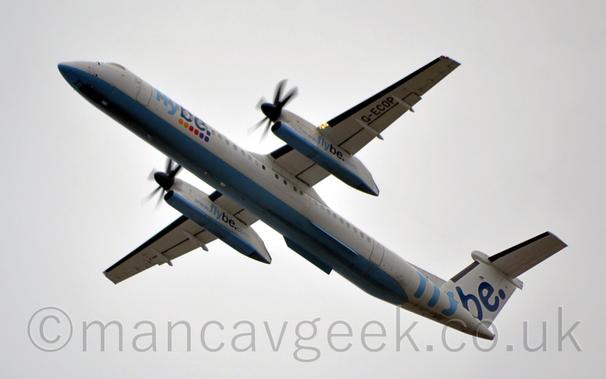 Low side view of a high-winged, twin propellor-engined airliner flying from right to left at a very low altitude, with flaps extended from the rear of the wings, the undercarriage already stowed away, and the nose raised sharply, suggesting it has just taken off.
The plane is mostly white, with a pale blue belly, and light and dark blue "FlyBe" titles on the forward fuselage over a group of 6 coloured dot - 2 each yellow, red, and purple.
There are larger "FlyBe" titles on the tail, as well as the website address "www.flybe.com" on the sides of the engine pods under the wings, which also have a pale blue lower section.
The black registration "G-ECOP" is on the outer panels of the underside of the left wing.
Cloudy grey sky fills the rest of the frame.