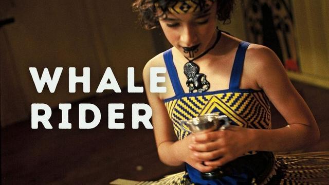 Still photo from the film Whale Rider. It shows a Māori girl in beautiful traditional clothing in blue and yellow. The film title is in bold white letters across the middle. The Journeys in Film logo is at the bottom.