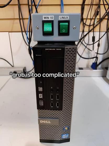 an image with a dell optiplex pc and a physical switch box on top, with options being win 10 and linux

the text below says "grub is too complicated"