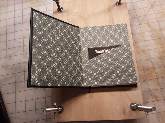 The front end pages showing a pocket. The pages are in a green, cream and black geometrical pattern.