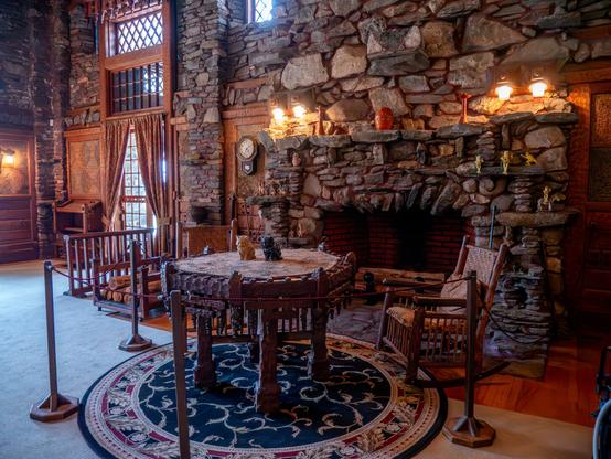 A large living room with wood furniture and stone fireplace