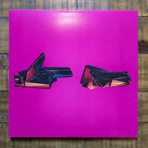RTJ4 on vinyl. A pair of hand sculptures, making the "first and gun" gesture, on a bright pink field. The hands are angular, low-poly, apparently some kind of distressed metal reflecting colored lights.