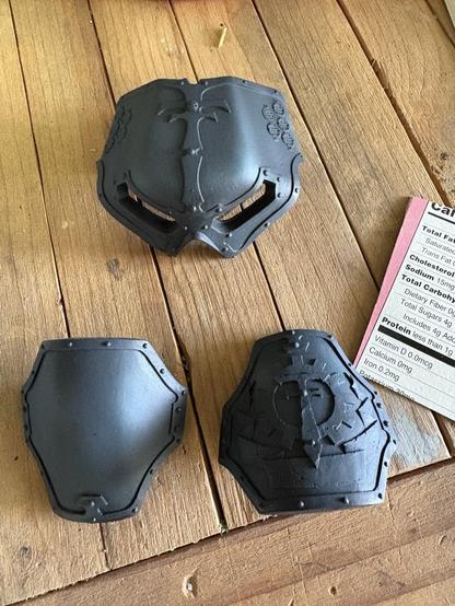 Two knee pads and a reaver helmet. They’re black, but with subtle blue/gray volumetric highlights.