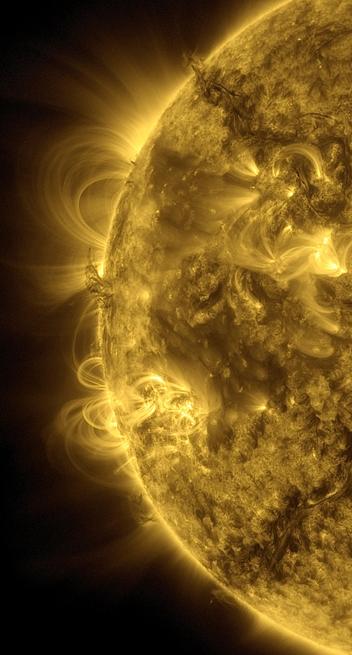 Der linke Rand der Sonne in gelber Farbe. Zahlreiche koronale Loops führen von der Oberfläche weg und in großen, sehr fein strukturierten Bögen zu ihr zurück. Dazwischen und darüber zwei Stellen mit dunklerer Sonnenmaterie, die sich von der Oberfläche gelöst hat und durchs All wabert, bevor sie wieder auf die Sonne fallen dürfte.