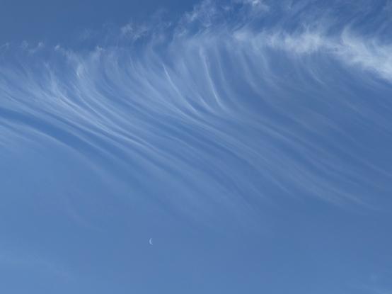 Ciel avec un léger voile. Un croissant de Lune est visible en bas de la photo.