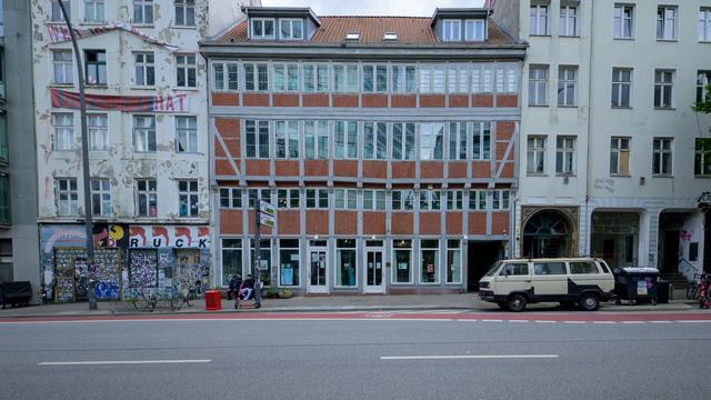 Renoviertes mittelalterliches Haus zwischen zwei deutlich moderneren Häusern in Hamburg.

Das linke Haus sieht ein wenig verfallen aus, hat ein politisches Transparent und reichlich Graffiti.