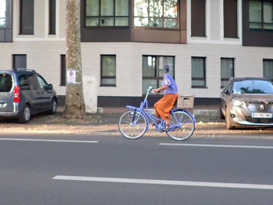 Cycliste avec un t-shirt violet sur un vélo violet